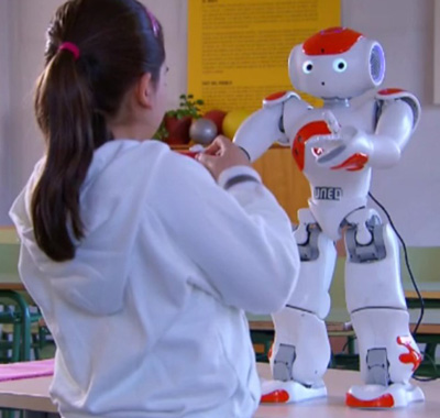 Niña interactuando con el robot humanoide Niña interactuando con el robot humanoide